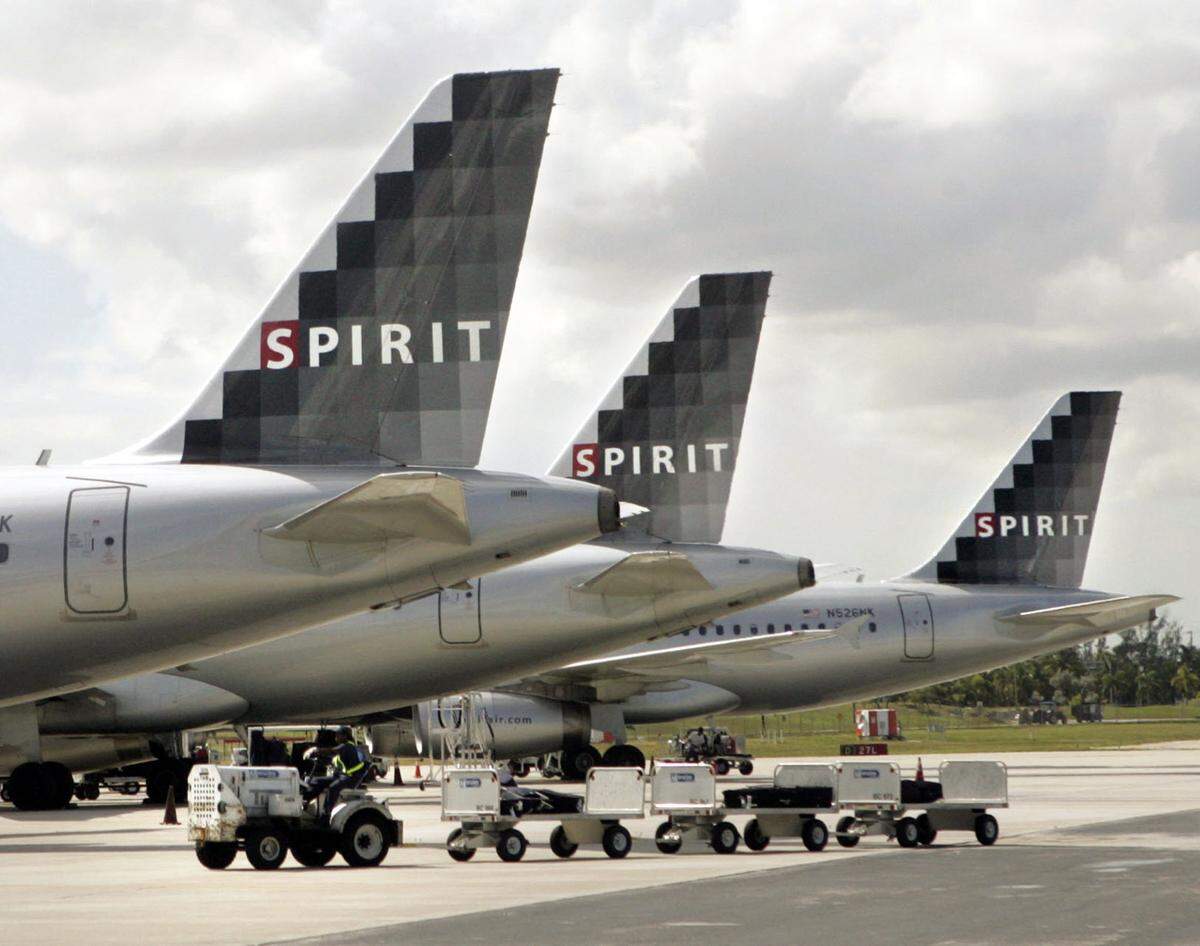 In 2007, a Spirit Airlines baggage handler drives carts past three Spirit jets outside Terminal 4 at Fort Lauderdale-Hollywood International Airport.